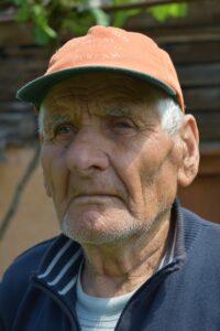 man in blue and white striped polo shirt wearing orange cap
